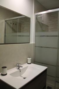 a bathroom with a white sink and a mirror at Casa MENDILUCE in El Pueyo de Jaca