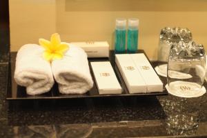un vassoio con asciugamani e un fiore giallo di Hotel Sinar 1 a Sedati