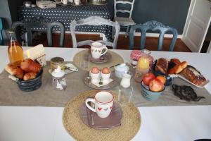 ein Tisch mit einem Frühstück mit Eiern und Croissants in der Unterkunft Les 2 Granges Chambre d'hôtes in Bérig-Vintrange