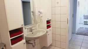 a white bathroom with a sink and a mirror at Ferienwohnung Gockels-Auszeit in Bad Wildungen +11 photos