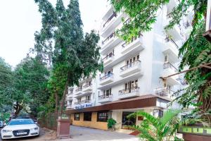 a white building with a car parked in front of it at West End Hotel Opp Bombay Hospital in Mumbai