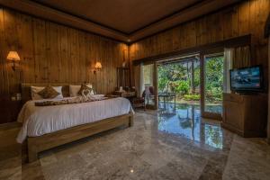 um quarto com uma cama e uma televisão em Cendana Resort & Spa by Mahaputra em Ubud