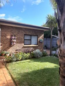 ein Backsteinhaus mit einem Fenster und einem Hof in der Unterkunft On Yonder Hill in Kapstadt