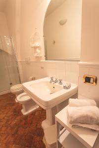 a bathroom with a sink and a toilet and a mirror at Sant'Angelo 42 in Orvieto