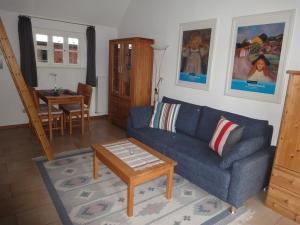 a living room with a blue couch and a table at Haus "Am Kienmoor" in Bad Zwischenahn +8 photos