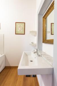 a white bathroom with a sink and a mirror at Sant'Angelo 42 in Orvieto