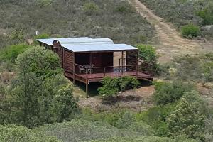 una casa con techo azul en una colina en Gaia's Gift - Shepherd's Cottage, en Swellendam