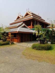 um grande edifício de madeira com telhado em Heanmaeloung Resort. em Chiang Mai