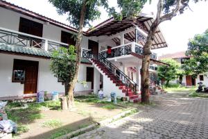 - un bâtiment blanc avec un escalier devant dans l'établissement Arjuna 31, à Yogyakarta