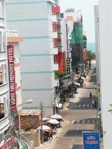 uma rua da cidade com um edifício e uma rua com pessoas em Hoang Kim Hotel em Vung Tau