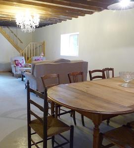 jadalnia z drewnianym stołem i krzesłami w obiekcie Gite des Loges du Château de Matel w mieście Roanne
