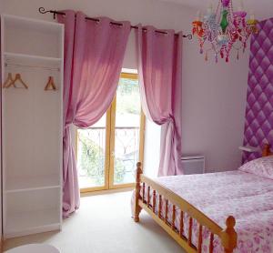 sypialnia z łóżkiem z różowymi zasłonami i oknem w obiekcie Gite des Loges du Château de Matel w mieście Roanne