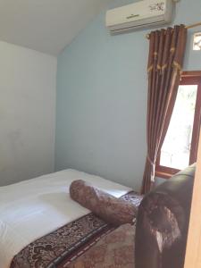 - une chambre avec un lit et une fenêtre dans l'établissement Fajar Home Stay Batukaras, à Batukaras