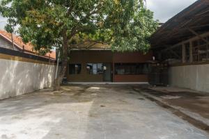 an empty parking lot in front of a building with a tree at RedDoorz near Cikampek Mall Karawang in Karawang
