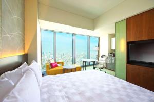 a hotel room with a bed and a television at Osaka Marriott Miyako Hotel in Osaka