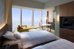 a hotel room with two beds and a television at Osaka Marriott Miyako Hotel in Osaka