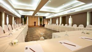 a banquet hall with white tables and white chairs at M2 de Bangkok Hotel in Bangkok
