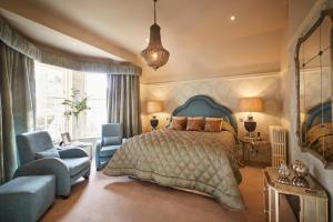 um quarto com uma cama, um sofá e uma cadeira em Cairn Lodge em Auchterarder