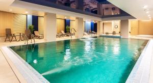 una gran piscina de agua azul en un hotel en Apartinfo Nowa Motława SPA, en Gdansk