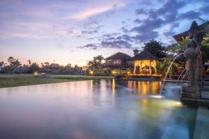 a pond in front of a house with a fountain at Cendana Resort & Spa by Mahaputra in Ubud