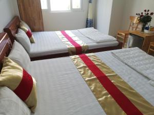 two beds in a room with two bedsskirts at Hoang Kim Hotel in Vung Tau