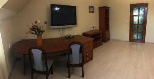 a living room with a desk with a television on the wall at Lotusz Apartments in Nyiregyhaza in Nyíregyháza
