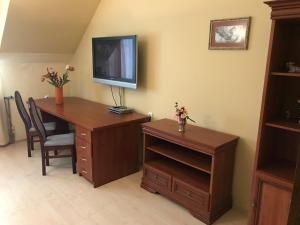 a room with a desk with a television on a wall at Lotusz Apartments in Nyiregyhaza in Nyíregyháza
