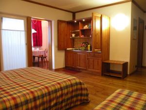 a bedroom with a bed and a kitchen with a sink at Hotel Garni Civetta in Selva di Cadore