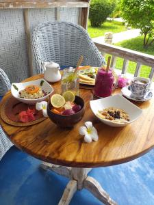 una mesa de madera con platos de comida. en Casa Azzurra en Gili Air