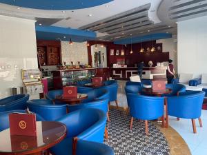 a restaurant with blue tables and blue chairs at Hala Inn Hotel Apartments - BAITHANS in Ajman 