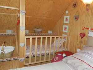 a childs bedroom with a crib and hearts on the wall at Gîte et Chambre D'hôte in Saint-Just-de-Claix