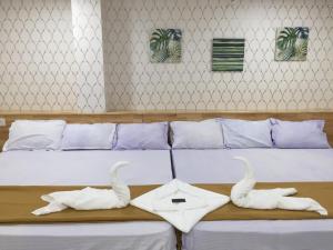 a bed with two white towels on a table at ADITI ROOMS in Tiruchchirāppalli