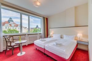 a hotel room with a bed and a large window at Come Inn Berlin Kurfürstendamm in Berlin