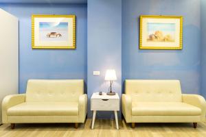 two chairs and a table in a room with blue walls at Good time warm home in Tainan