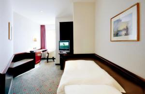 
a hotel room with two beds and a television at Hotel Imperial in Cologne
