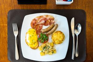 a plate of breakfast food with sausage potatoes and eggs at The Aviary Hotel in Siem Reap