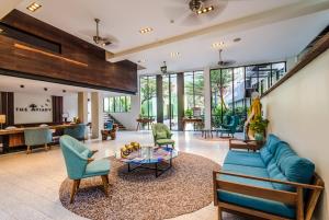 a living room with a blue couch and chairs at The Aviary Hotel in Siem Reap