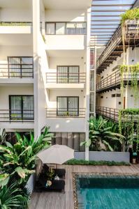 an apartment building with a pool and an umbrella at The Aviary Hotel in Siem Reap