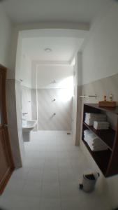 a white bathroom with a sink and a toilet at My Home Resort in Matara