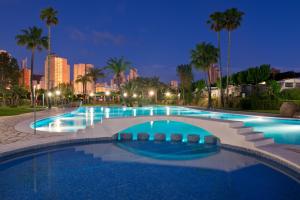a large swimming pool with a city skyline in the background at Camping Villasol in Benidorm