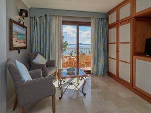 a living room filled with furniture and a window at Hotel Petit Cala Fornells in Paguera