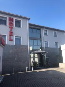 a white building with a red sign on it at Hotel Arkadia in Końskie