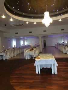 KońskieにあるHotel Arkadiaの白いテーブルと椅子が備わる宴会場