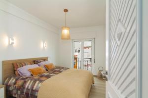 a bedroom with a bed and a pendant light at Casa EVA Amêndoa in Tavira