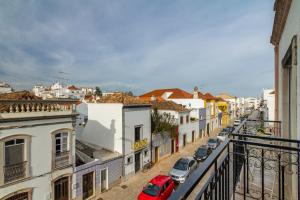 einen Balkon mit Blick auf eine Stadtstraße in der Unterkunft Casa EVA Amêndoa in Tavira