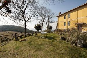 un perro tirado en el césped junto a un edificio en Agriturismo Fattoria Poggio Boalaio, en Orvieto