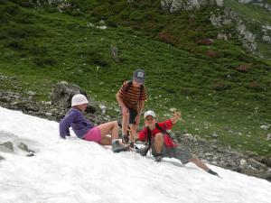a group of three people sitting in the snow at Hotel Garni Civetta in Selva di Cadore