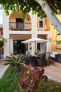 um pátio com uma mesa e um guarda-chuva em Amazing Villa with garden em San Miguel de Abona