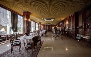 a dining room with tables and chairs and windows at Hotel Kyiv in Kyiv