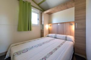 a bedroom with a large bed with a window at Camping Villasol in Benidorm